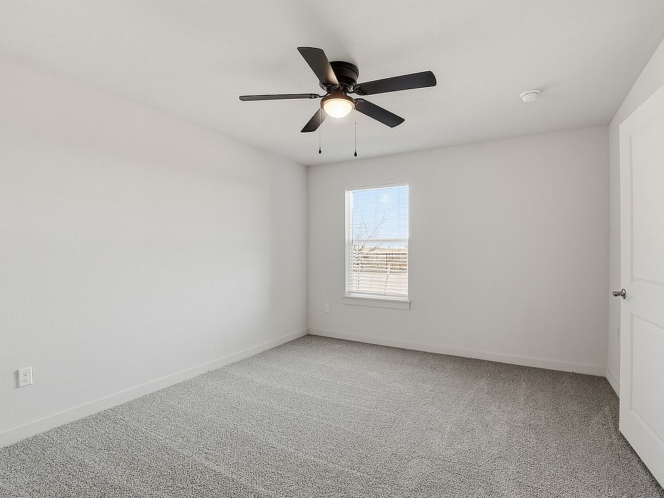 Bright and airy bedroom with plush gray carpeting, contemporary ceiling fan, and large window for natural light.