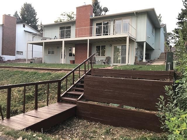 Backside of home with bridge to walking path