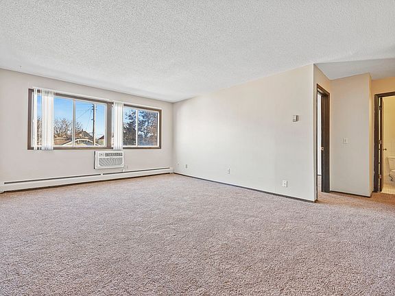 Living room with wall unit air conditioning