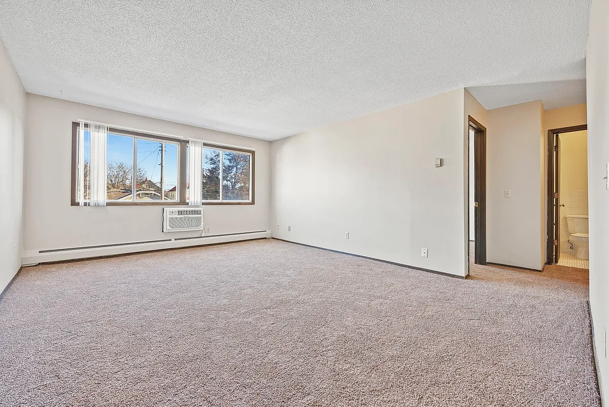Living room with wall unit air conditioning - Hennepin Apartments