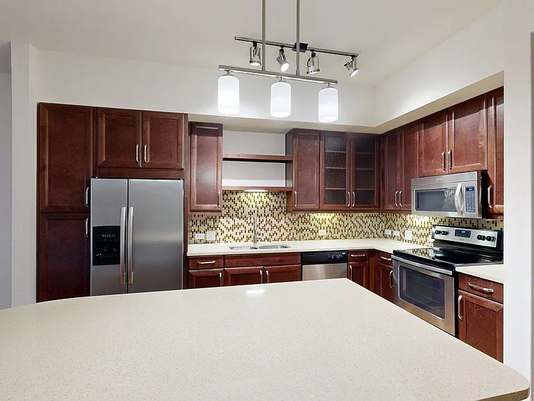 Apartment Kitchen with Quartz counter tops and Wood Style Flooring.