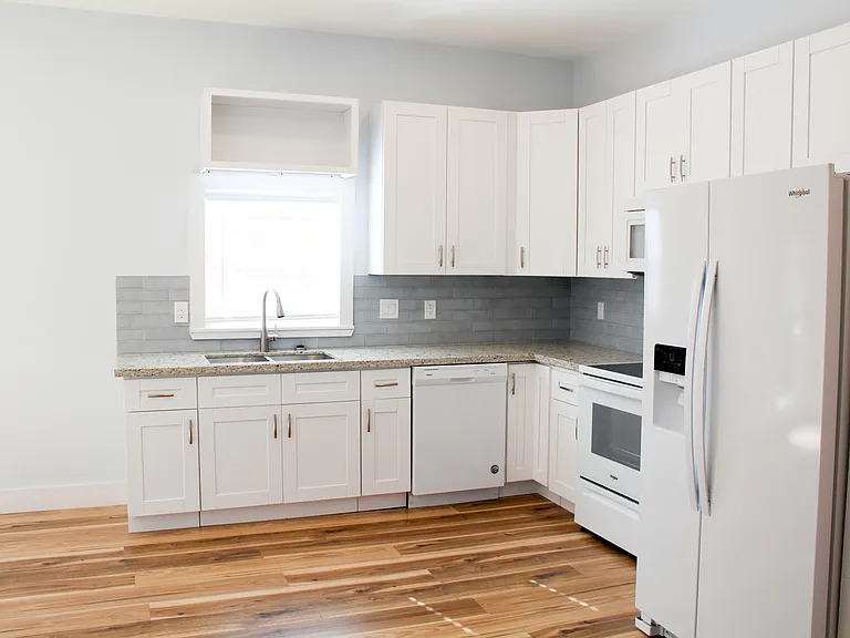 Immaculate kitchen with granite countertops, all brand-new appliances, lots of storage in new cabinetry.