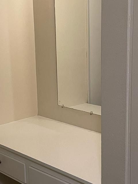 Vanity in hallway across from bathroom