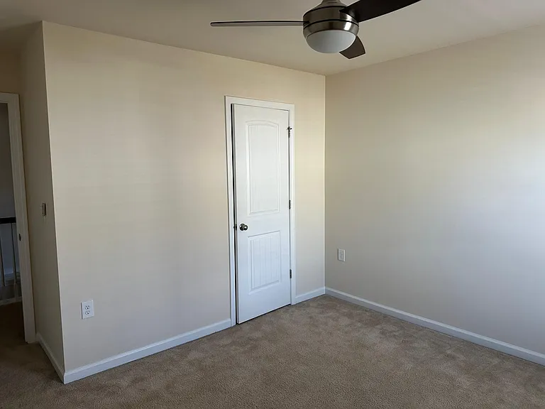 A view from the opposite corner within bedroom 1. The natural light to the right is from a window. The door in front of view is the closet.