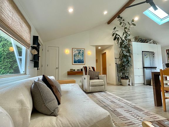 Living space is bright and cozy with two skylights and a ceiling fan.