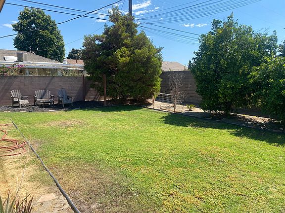 Large backyard with fruit trees, fire pit, and seating area.