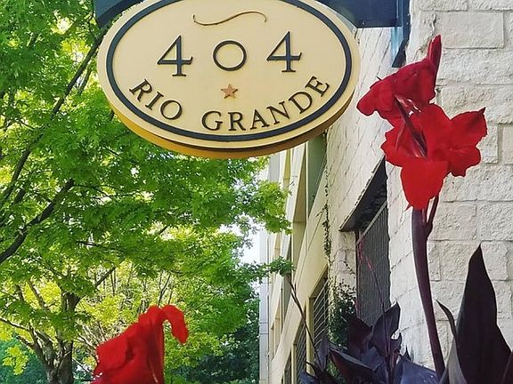 Street side monument sign near tree lined sidewalk