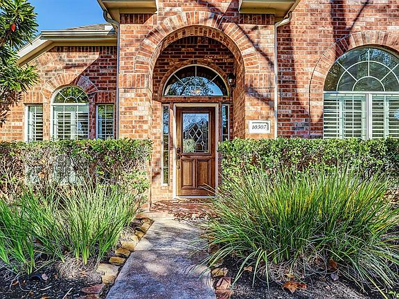 Guests will enter this extraordinary home through an impressive covered brick entry surrounded by mature landscaping. Let's take a closer look. I promise, you will not be disappointed.