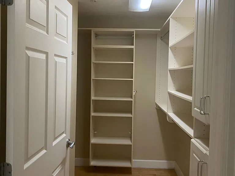 Walk-in closet in master bathroom is spacious and offers shelving, dresser rods, and shoe bins.