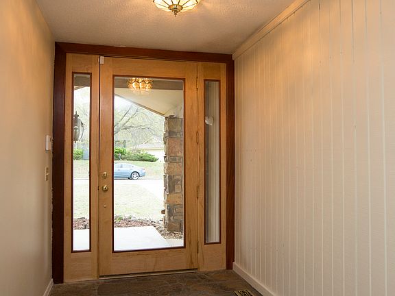 Covered front porch leads to this glass & hardwood front door w sidelights.  Flagstone floor & security system.