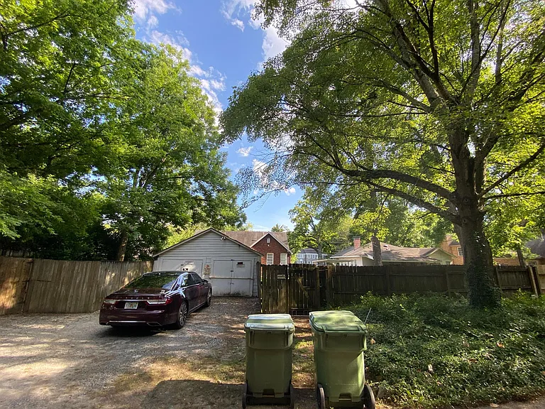 View of property from street behind home. Apartment rental includes one parking spot behind the shed and private access to one side of the shed for storage or parking.