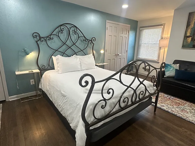Upstairs bedroom featuring a queen-sized iron bed _ classic style and cozy comfort.