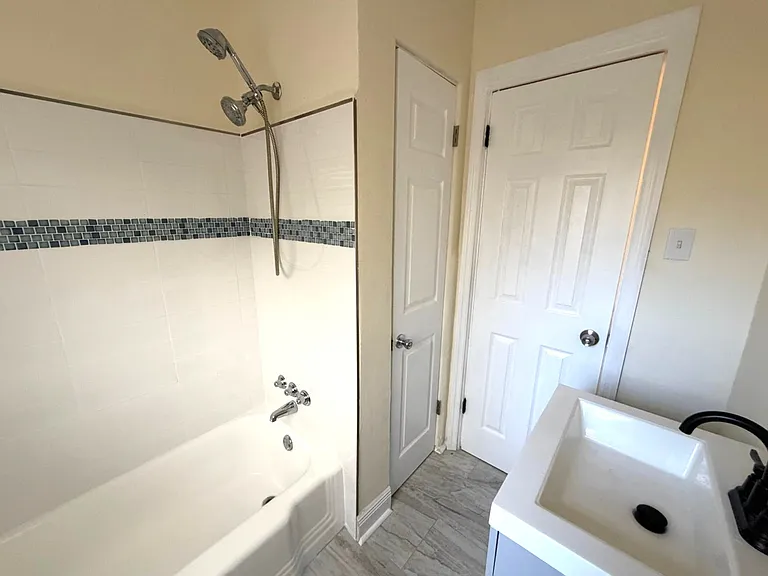 Newly renovated bathroom with tiling, flooring, vanity, closet storage, and toilet. All fresh and modern.
