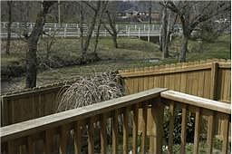 Corner lot with privacy fence, decking and small terrace outdoors.