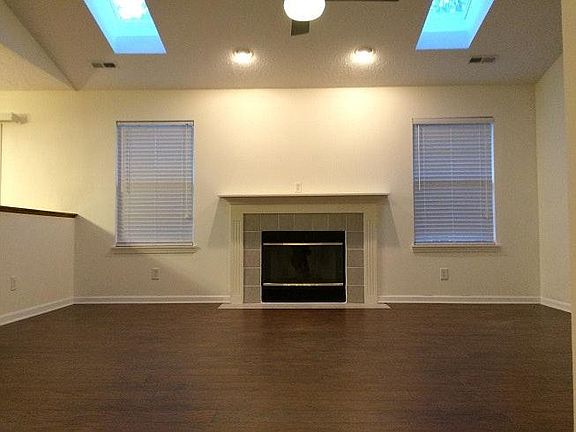 Great room with sky lights, ceiling fan & fireplace