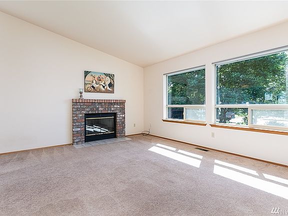 Double picture windows and cozy gas fireplace provide wonderful ambience year round. There is a sunshade on the home's exterior to help keep things cooler on those long summer evenings.