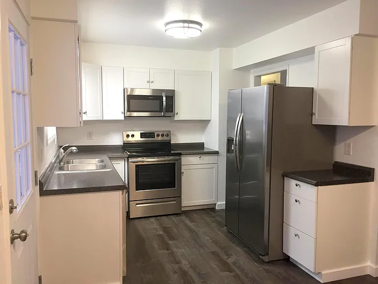 Bright Kitchen with newer cupboards, appliances, flooring, and paint.