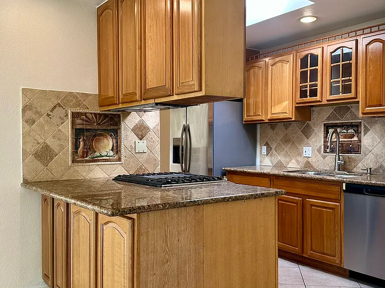 Kitchen with eat-in counter, stainless steel appliances, recessed lighting and skylight