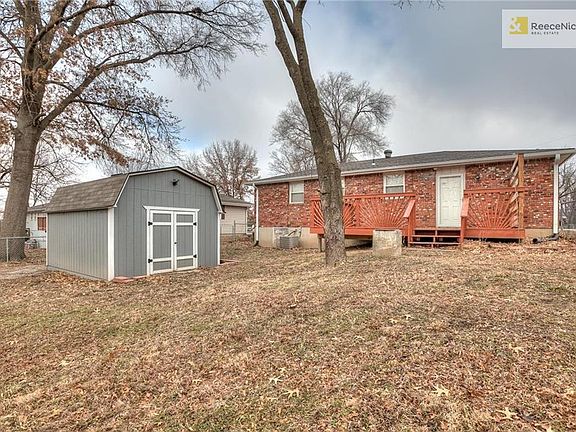 This shed!!!!!  It has a ceiling fan, electricity, and cable!!!  It is a nice area for hobbies, gardening, and/or storage. The cement block at the end of the deck is an old cellar chimney that was filled in.  You can see to the right of the AC unit is the door to access the crawl space.  It is a much easier to access than most crawl spaces.