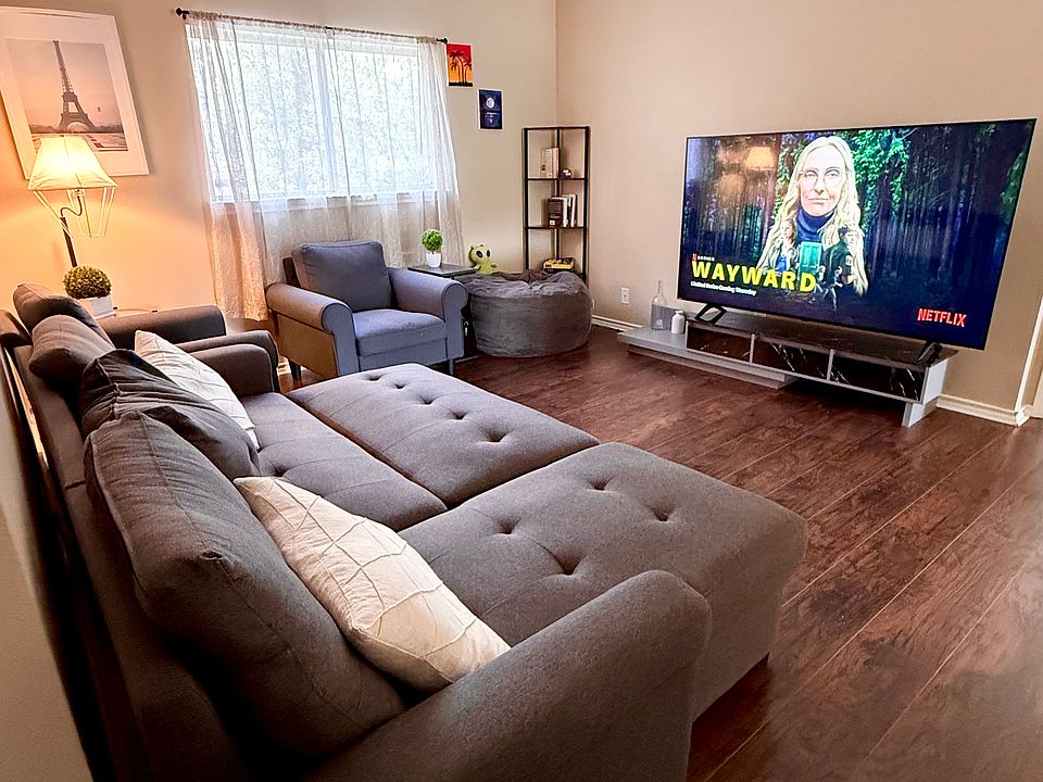 upstairs entertainment area with sofa seating for 5-6 people, includes a 75" wide Philips TV for movie nights