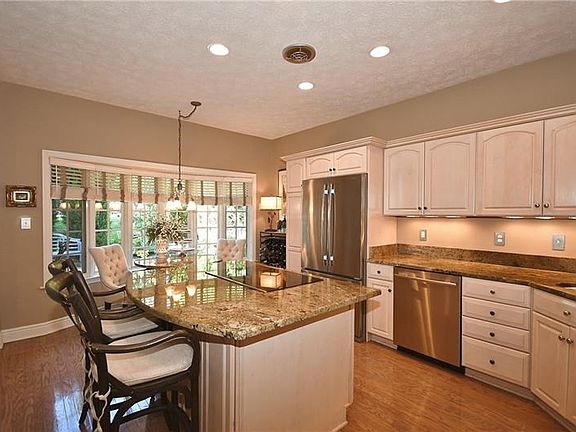 Gorgeous updated center island kitchen with granite counter tops under counter lighting and high end stainless steel appliances.