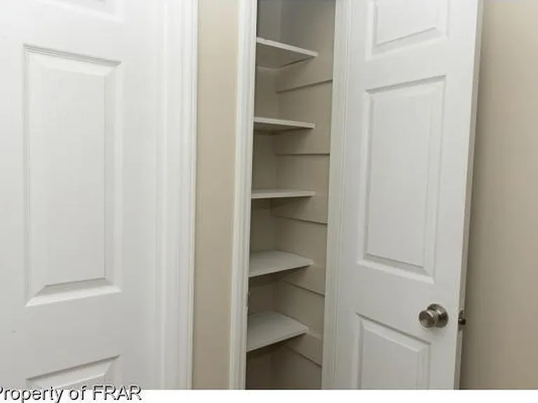 The storage shelves are adjustable, and the closet is nested on the ground floor near the stairs.