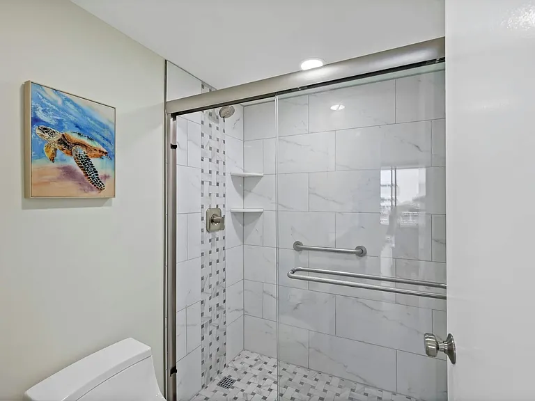 Luxurious primary bathroom featuring a enclosed private shower and toilet room