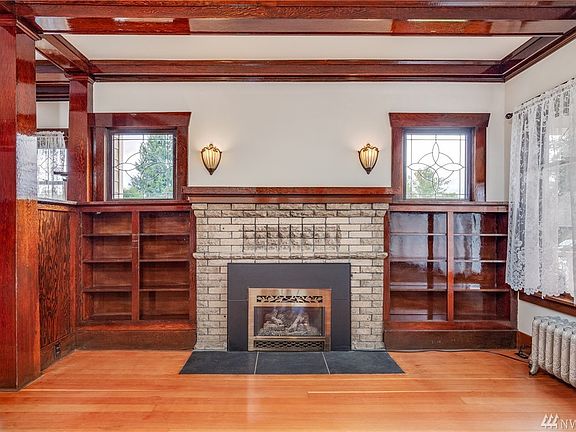 A frontal view of the gas insert fireplace, built-ins and sconce lights