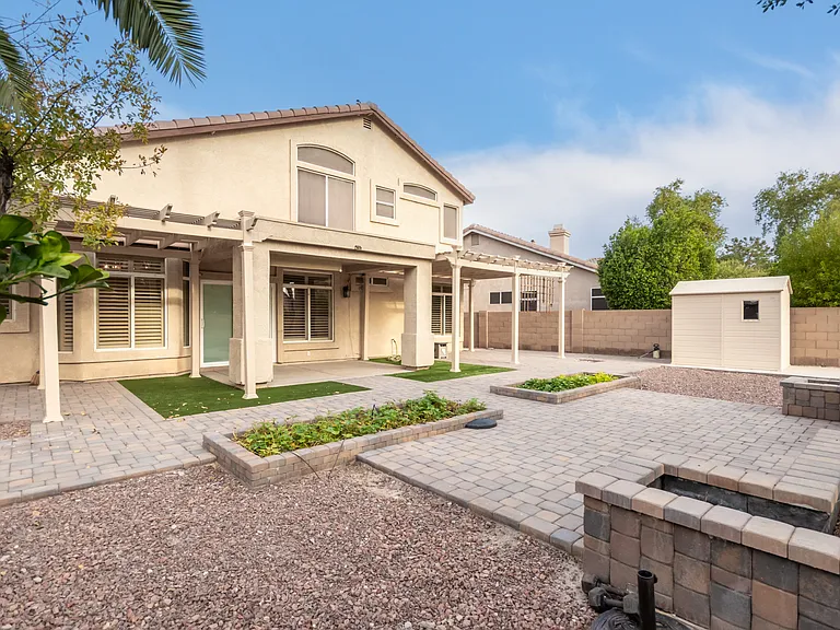 Backyard with Mature Trees, Paver Patio, Garden, and Artificial Turf.