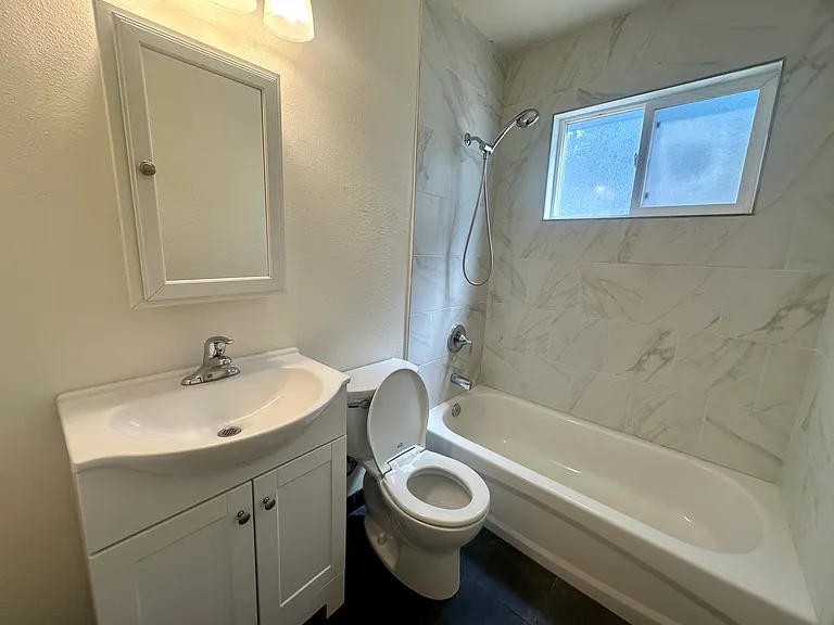 Newly tiled bathroom with updated features, clean and fresh!