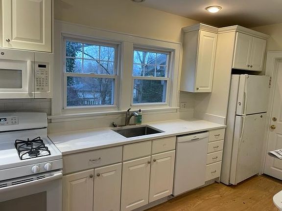 Kitchen with new quartz counter top and updated appliances. Gas stove, new sink, dishwasher, microwave and refrigerator. Plenty of storage.