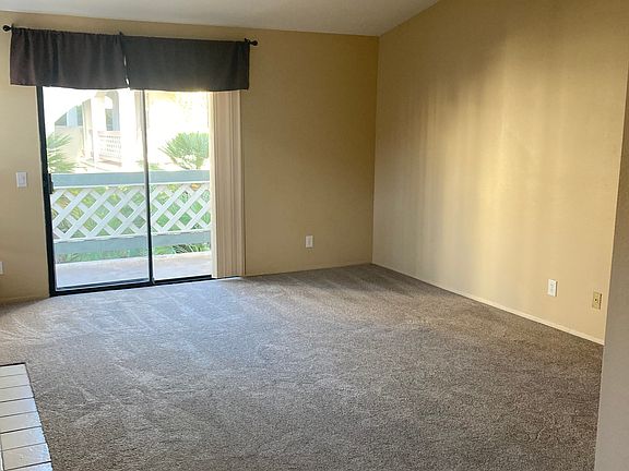 large living room w/ vaulted ceiling & outdoor balcony