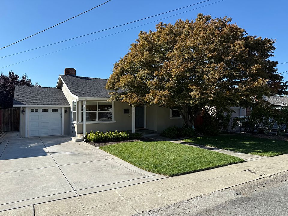 Front exterior view showcasing the garage, welcoming entryway, and beautifully landscaped front yard.