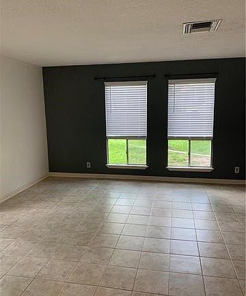 Living room in Unit A.  Large windows allow in plenty of sunlight.  Brand new 2" faux-wood blinds convey.