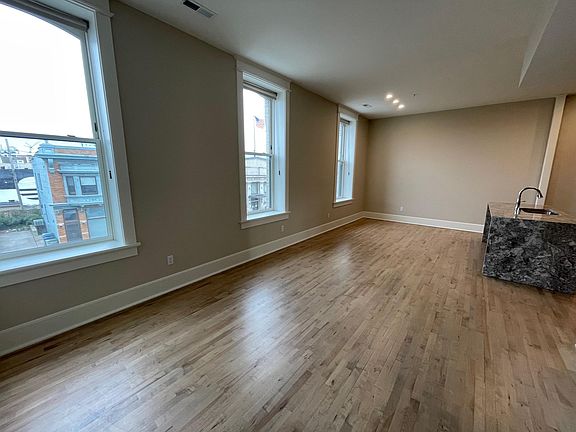 Spacious living area with three north-facing windows.