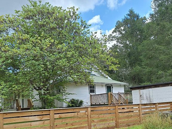 View of new fence put up within past year, with Can house showing where your family could store some goodies, & back deck showing also in photo