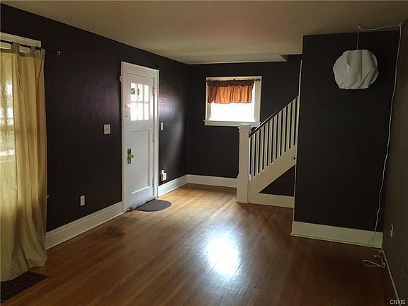 The View from the Living Room to the Front Door and the staircase which leads you upstairs.