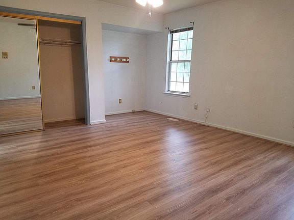 Empty MBR with vanity lighting/area. Access to walk-in attic storage is thru a door in center of mirrored closet.