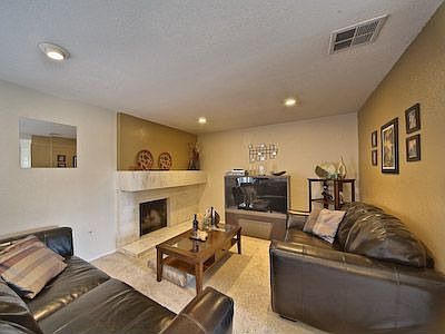 Living room with designer two tone paint, down lights and marble fireplace.