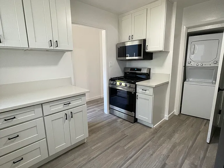 Kitchen with soft close cabinets, smart oven, microwave, and washer/dryer