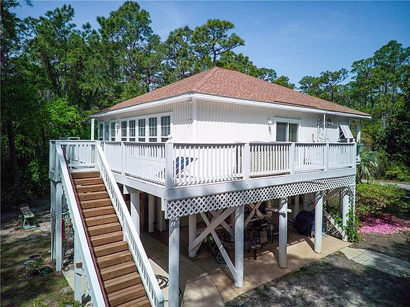 Rear view of house with roof with shingles, stairway, and a deck