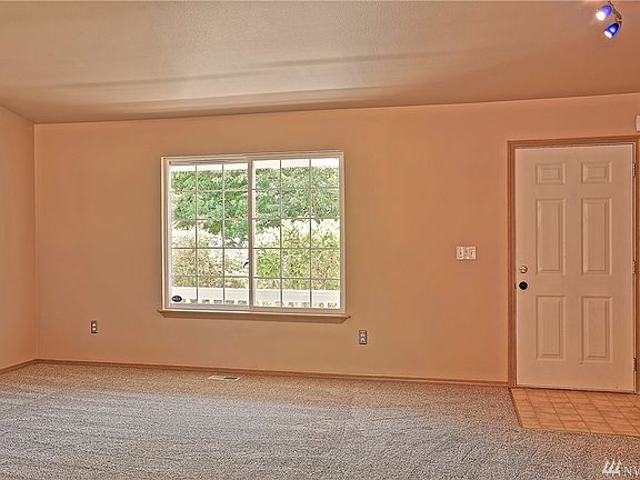 Living room facing the front door. The door to the right goes to the laundry room and then out to the garage. The entire interior of the home was just painted.