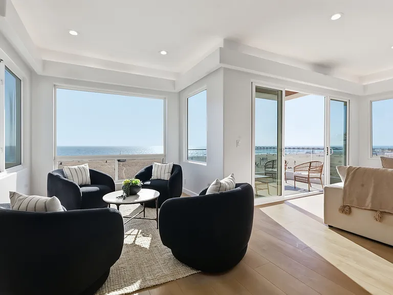 The main living room features breathtaking panoramic views from every corner, covered balcony, bar, and powder room.