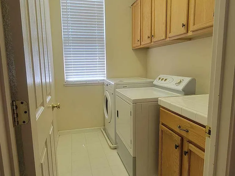 Upstairs laundry room has washer, dryer, and cabinet space - located between 3rd bathroom and 4th bedroom