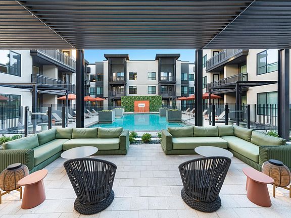A covered poolside lounge at Modera Higley Commons, designed for relaxed gatherings with layered seating, shaded comfort, and a refined outdoor atmosphere.