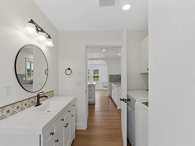 Combined laundry w/ half bath off kitchen.