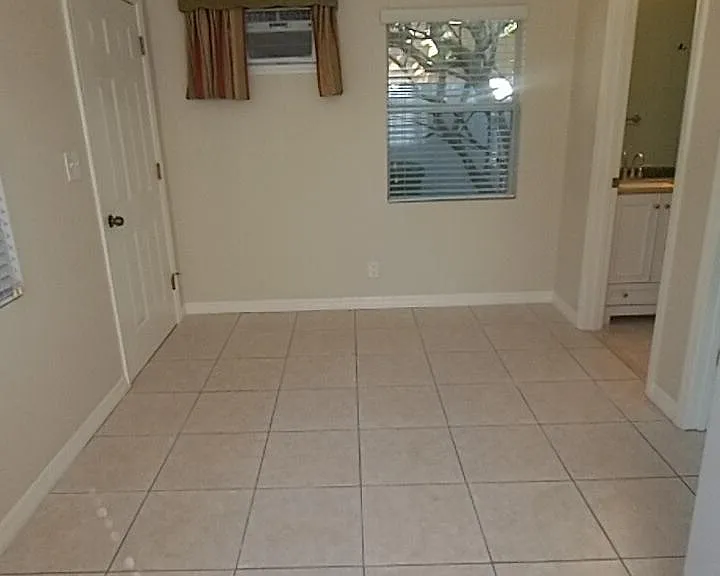 West side kitchen/living space with front door and bathroom entrance.