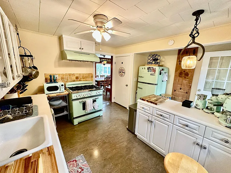 Plenty of storage and room to move in this lovely cottage kitchen featuring retro modern appliances.