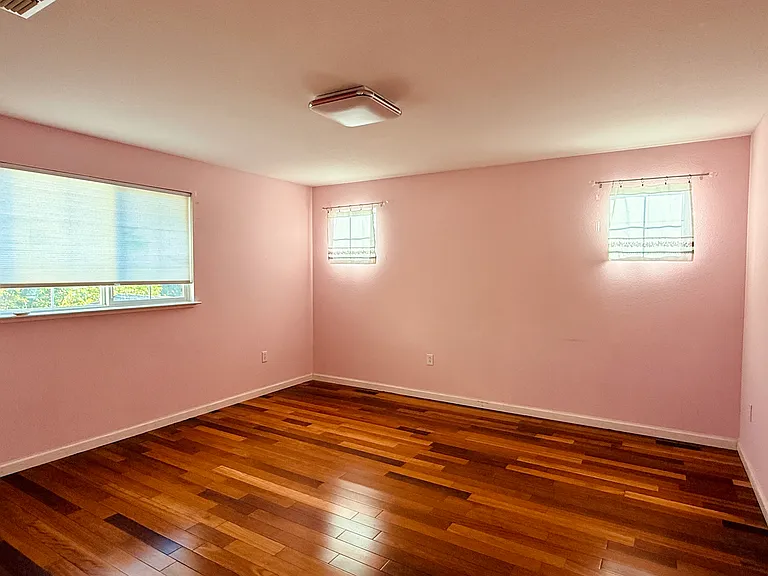 Bright upstairs bedroom with hardwood floors