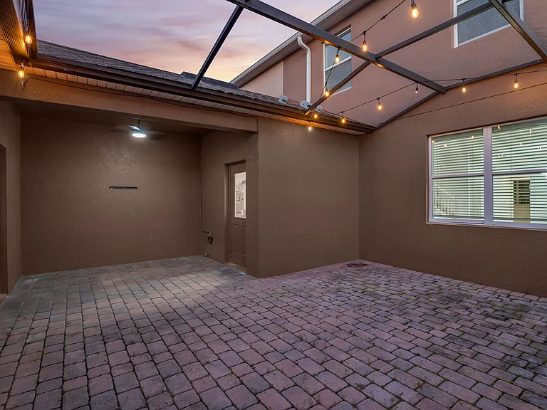 Spacious screen enclosed patio with covered walkway to detached 2 car garage